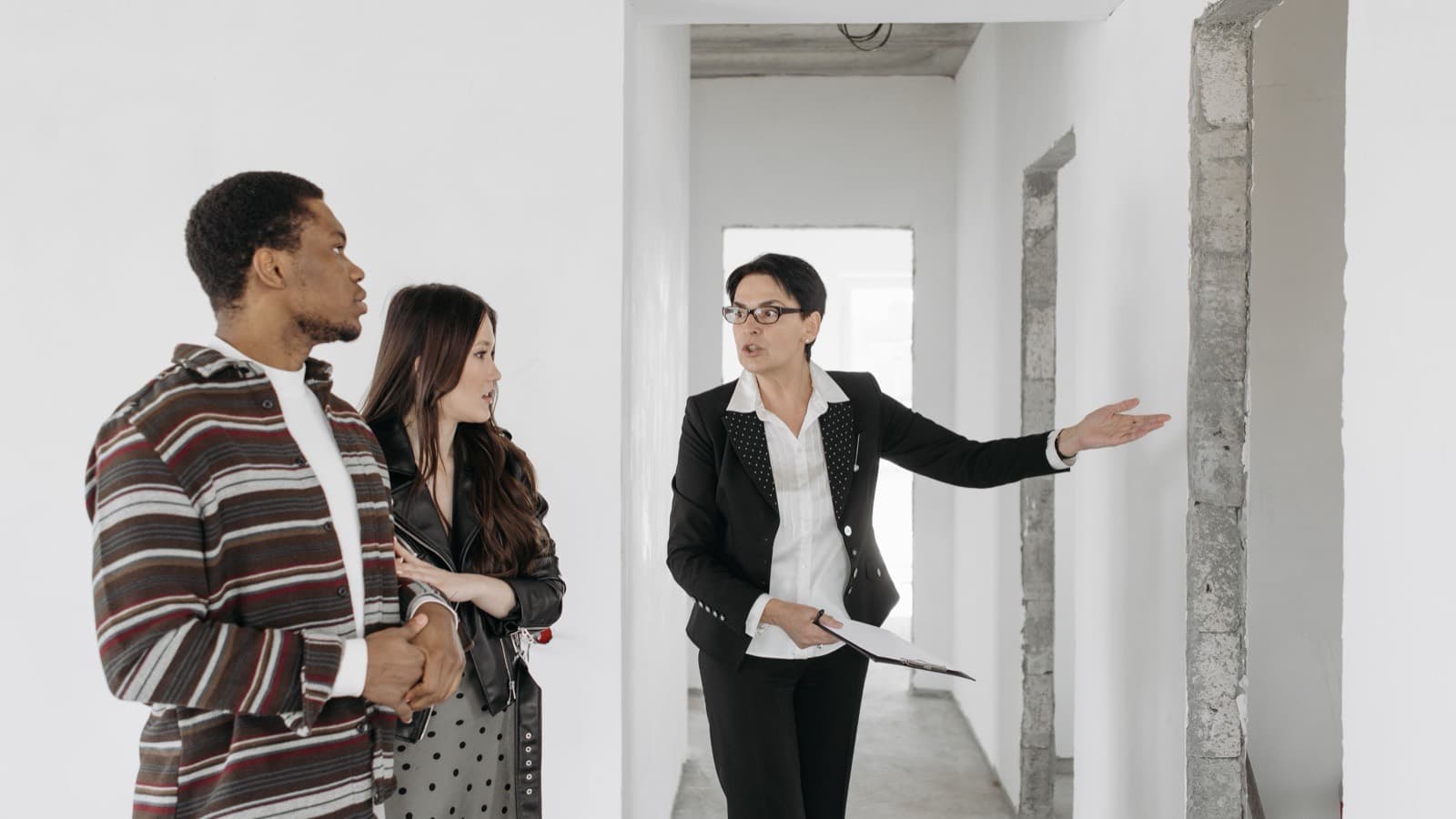 A sales executive showing an unfinished apartment to a couple during a site visit