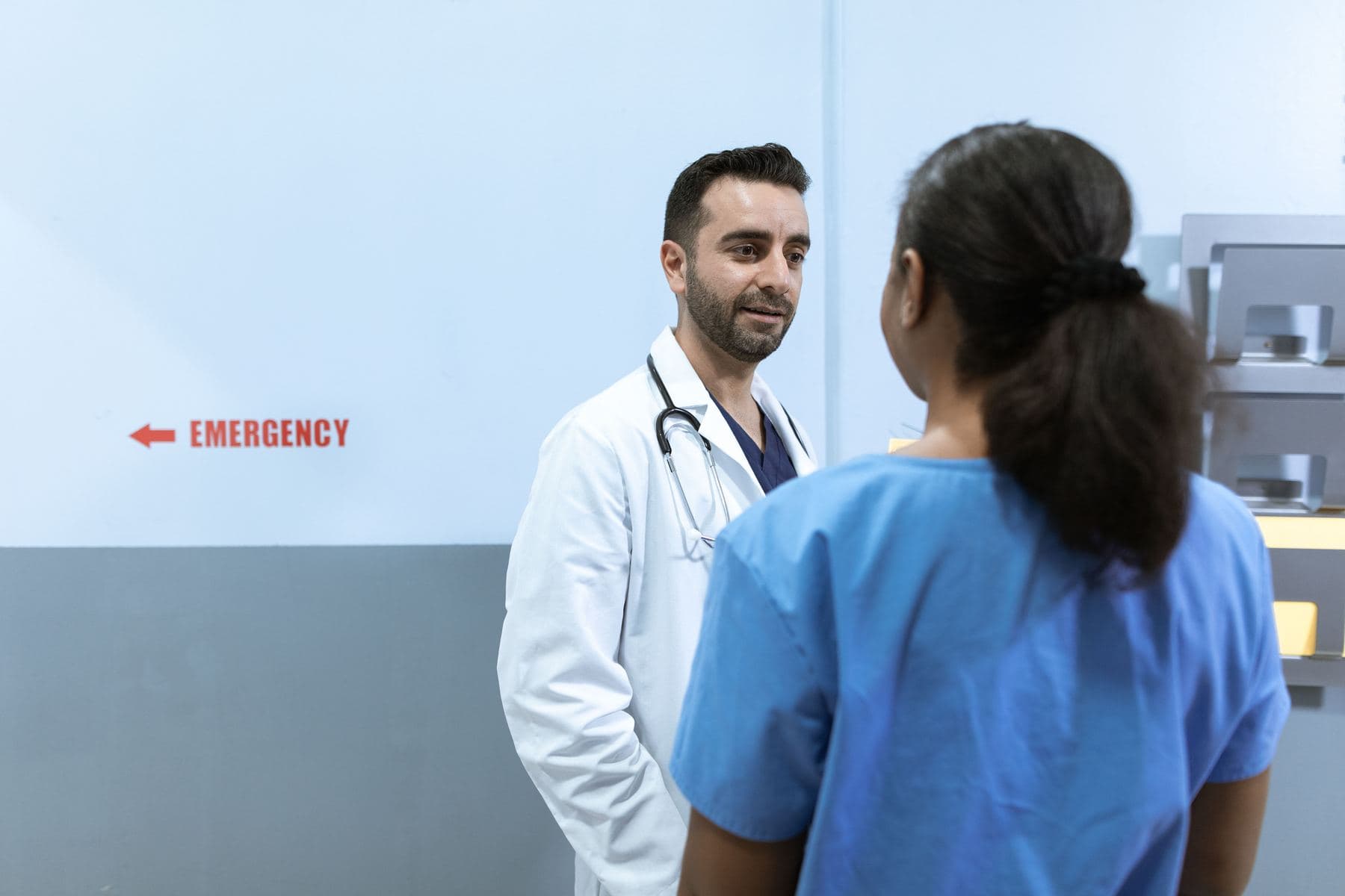A doctor talking with a nurse in a hospital corridor